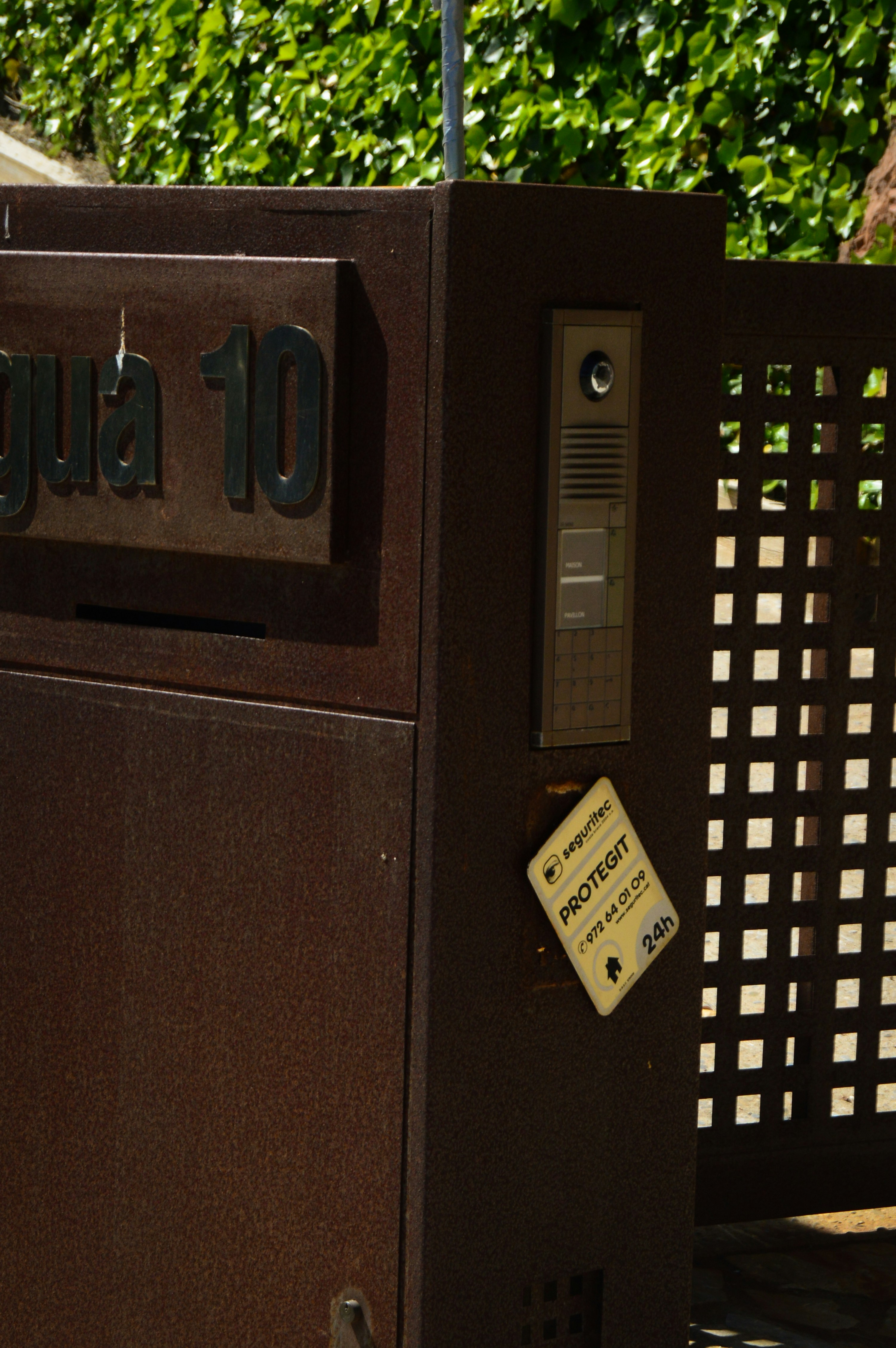 Building gate with a mounted intercom panel.