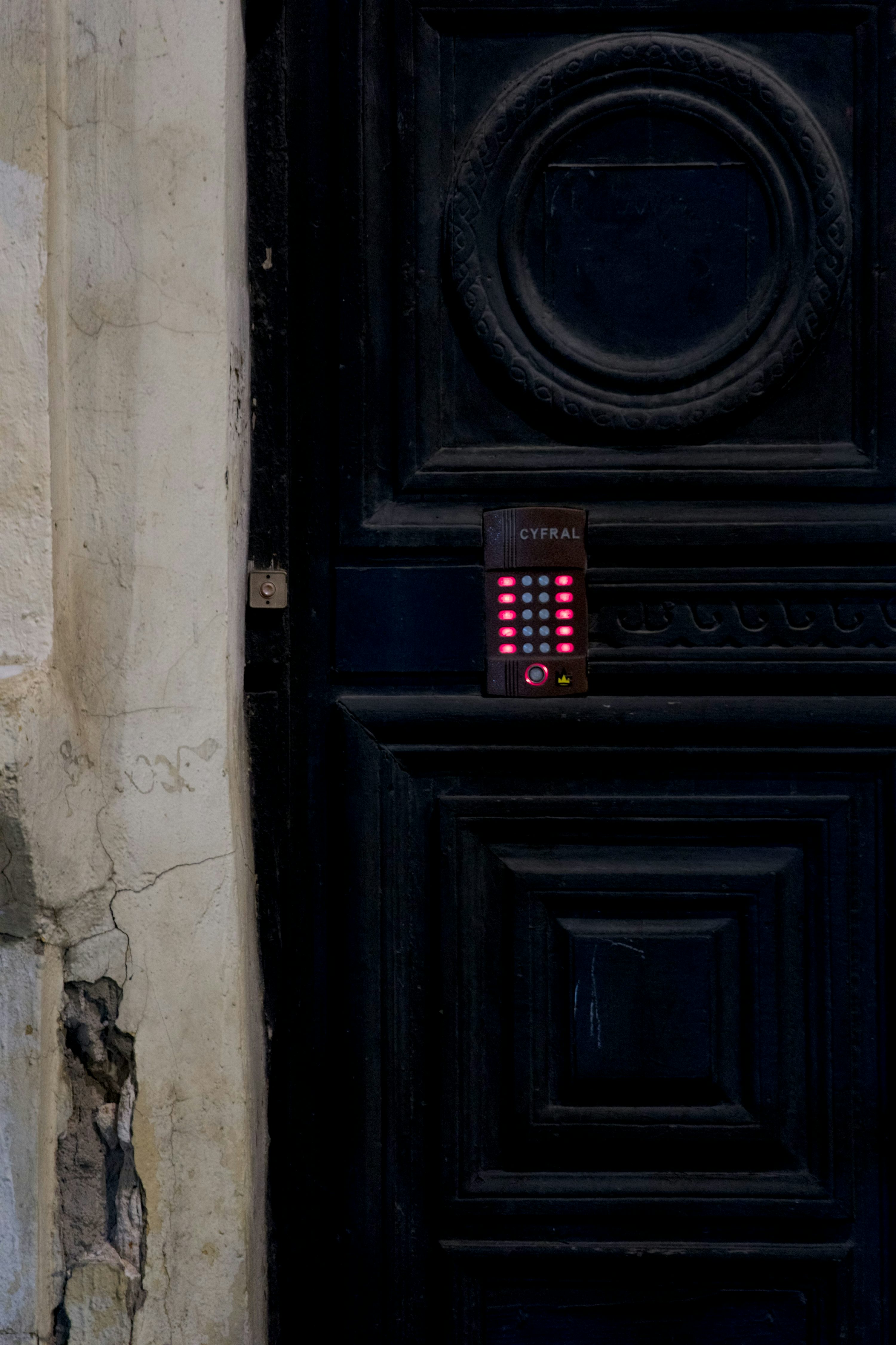 Door-mounted access control keypad on a dark entry door.